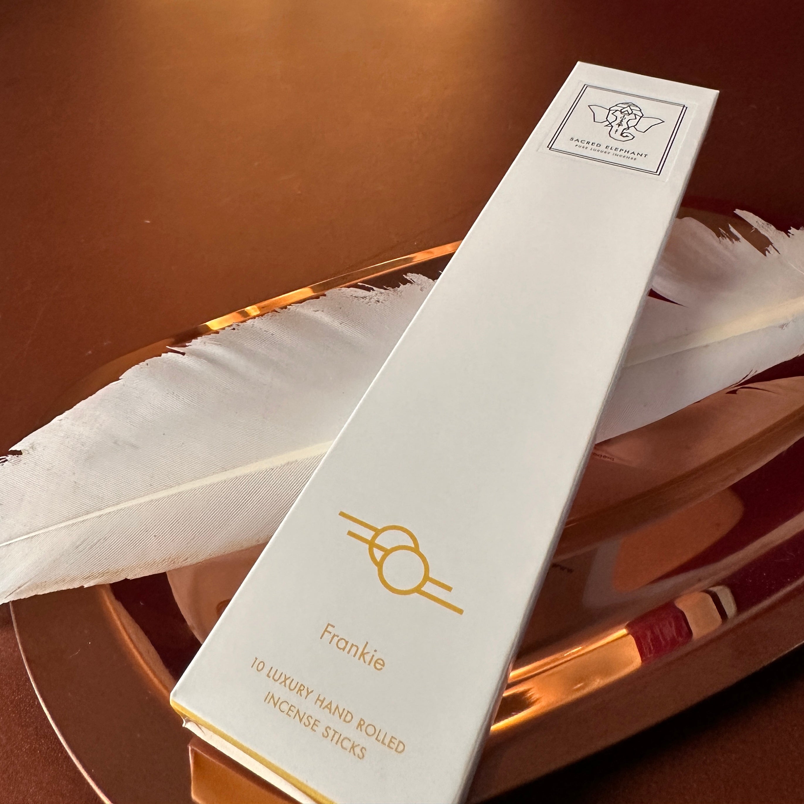 Frankie Räucherstäbchen von Sacred Elephant mit goldener Feder auf Kupfertablett