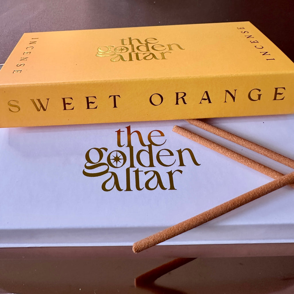 The Golden Altar Sweet Orange Räucherstäbchen – sonniger Duft mit goldener Verpackung auf weißem Untergrund, luxuriös und warm.