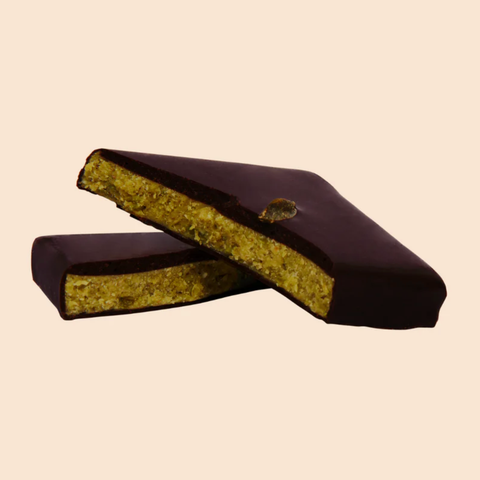 Diagonal gebrochene Bio-Schokoladenpraline mit Pistazienkern und adaptogenem Löwenmähne-Pilz – vegane, zuckerarme Ayurveda-Praline für Fokus & Balance.