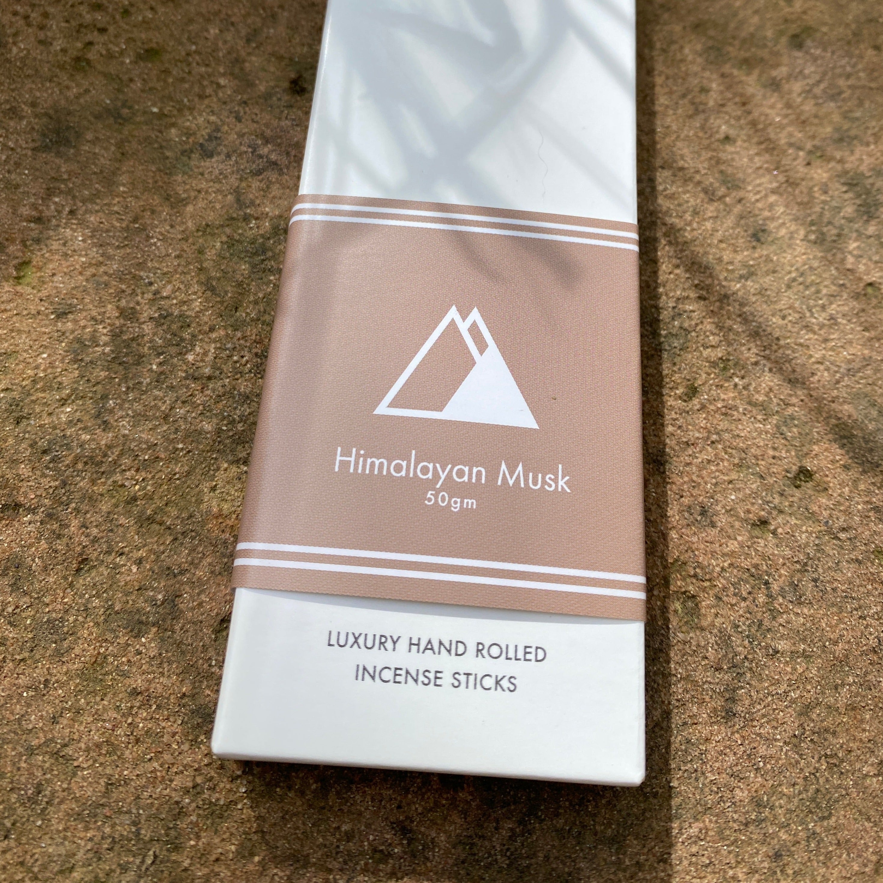 Sacred Elephant Himalayan Musk Räucherstäbchen 50 g – edle Packung in warmem Braunton auf Naturstein, aufgenommen im Tageslicht.